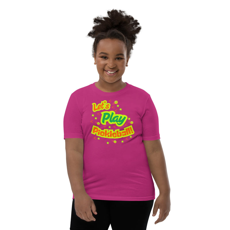 Pink youth T-shirt with neon pickleball graphic and "Let's Play Pickleball" text for kids by PeaMac Pickleball Tees.