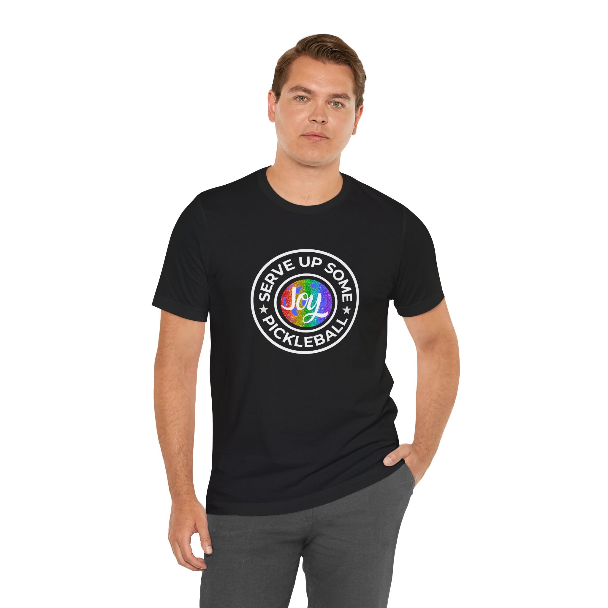 LGBTQ2 pride pickleball T-shirt by Printify featuring colorful rainbow design and "Serve Up Some Pickleball Joy" text on a casual T-shirt.