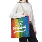 Colorful tote bag featuring crossed pickleball paddles and rainbow script design, perfect for carrying pickleball gear.