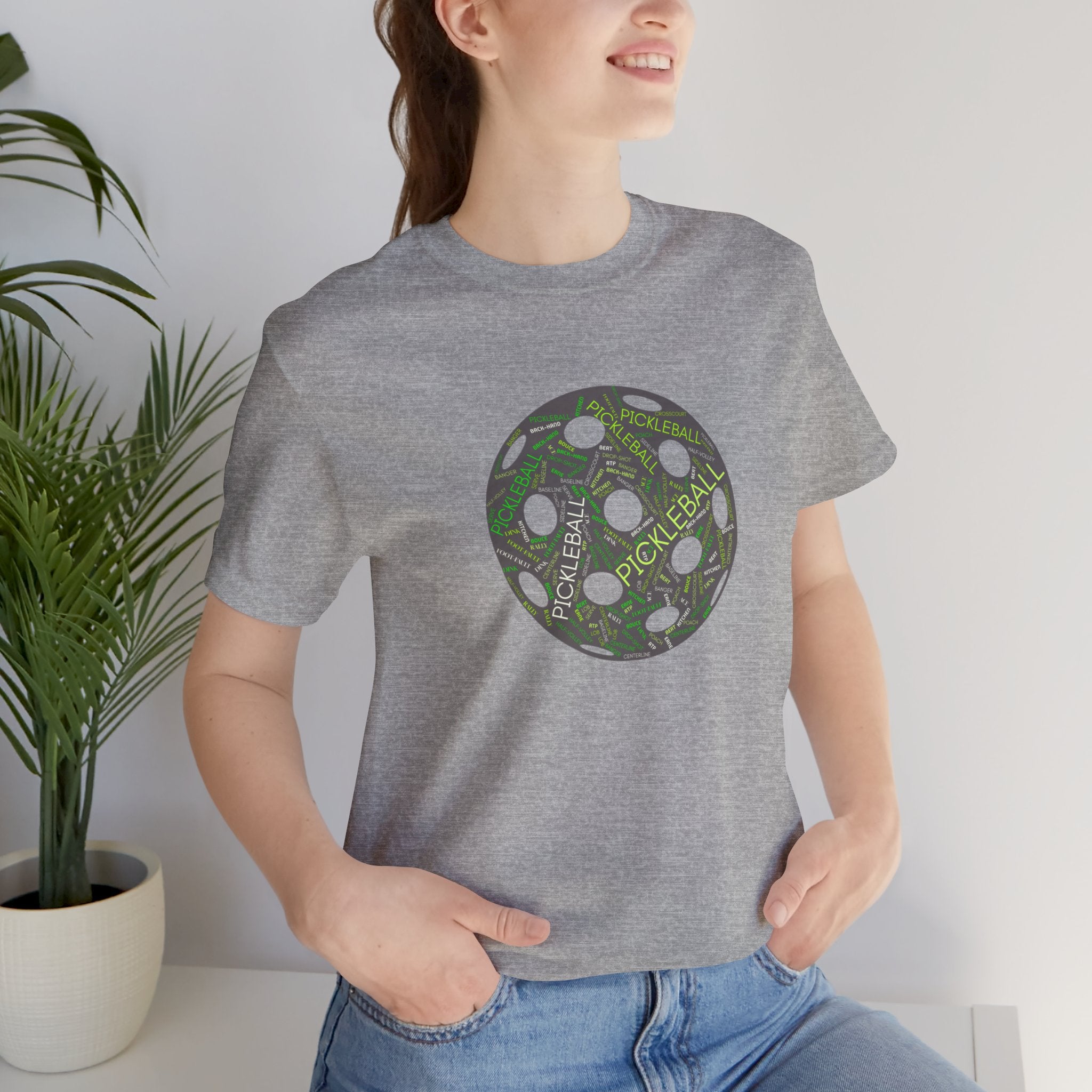 Pickleball Word Cloud T-Shirt with pickleball-shaped graphic, featuring words like dink, pickle, and kitchen on a casual printify tee.