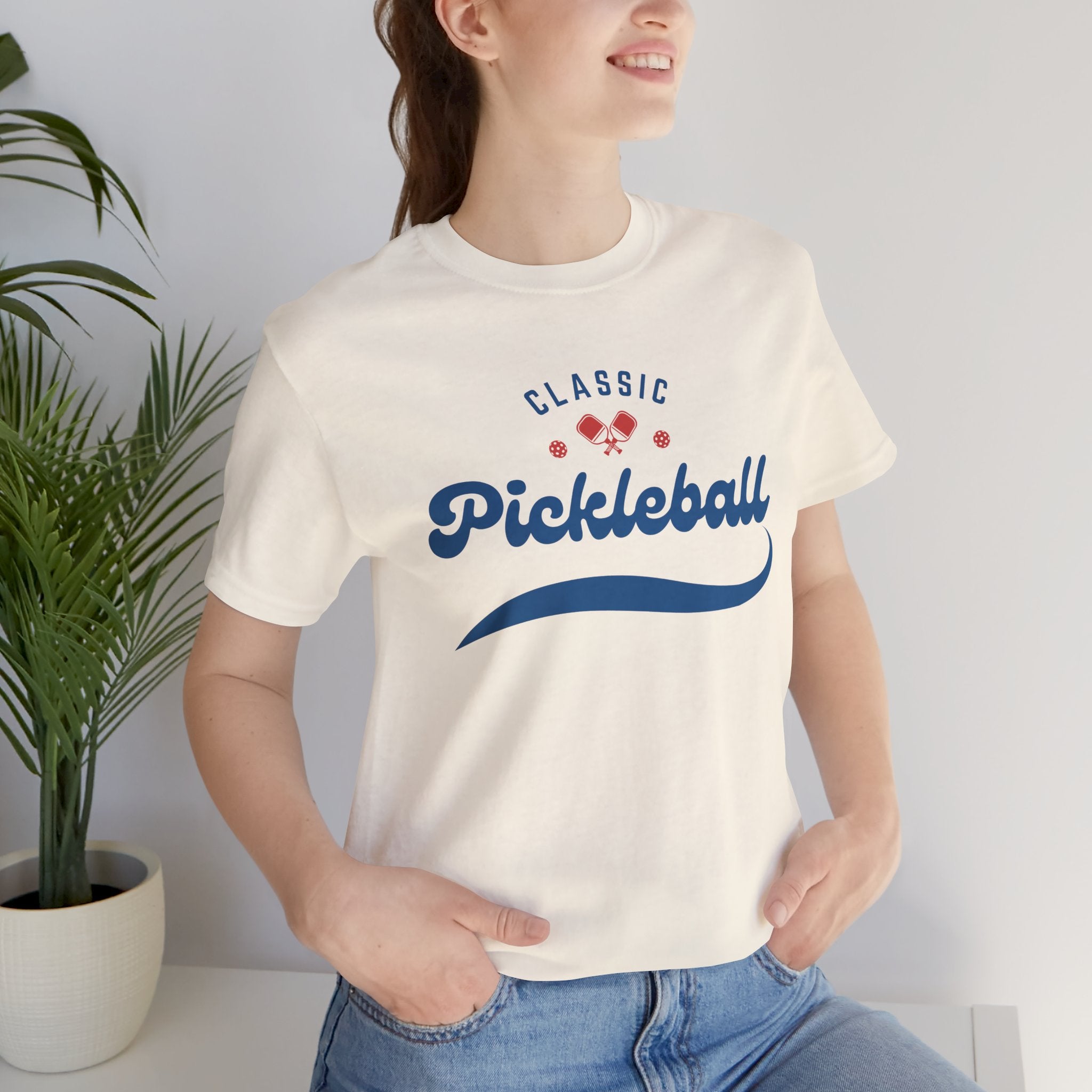 Red and blue pickleball script tee featuring paddle and ball design, casual cotton T-shirt by Printify.