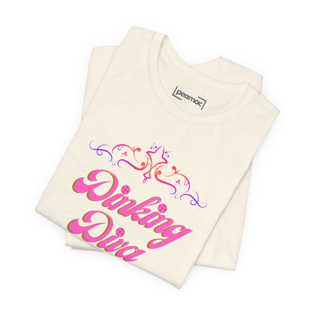 Pink Dinking Diva pickleball T-shirt with filigree design, athletic fit, and Printify branding displayed on the front.