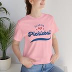 Red and blue pickleball script T-shirt featuring paddle and ball graphic, perfect for pickleball enthusiasts.