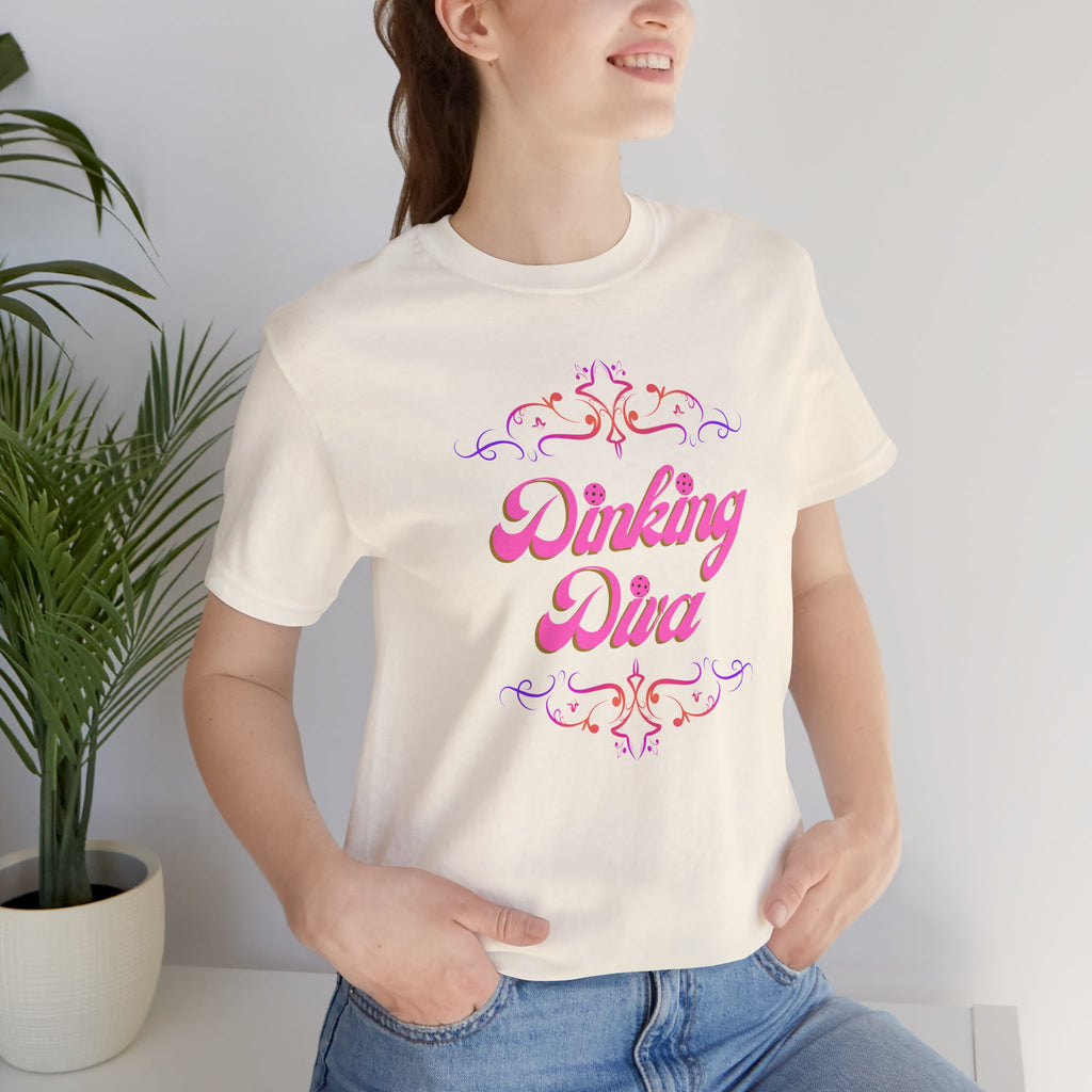 Pink Dinking Diva pickleball T-shirt with filigree design, athletic fit, and Printify branding on a casual women's tee.
