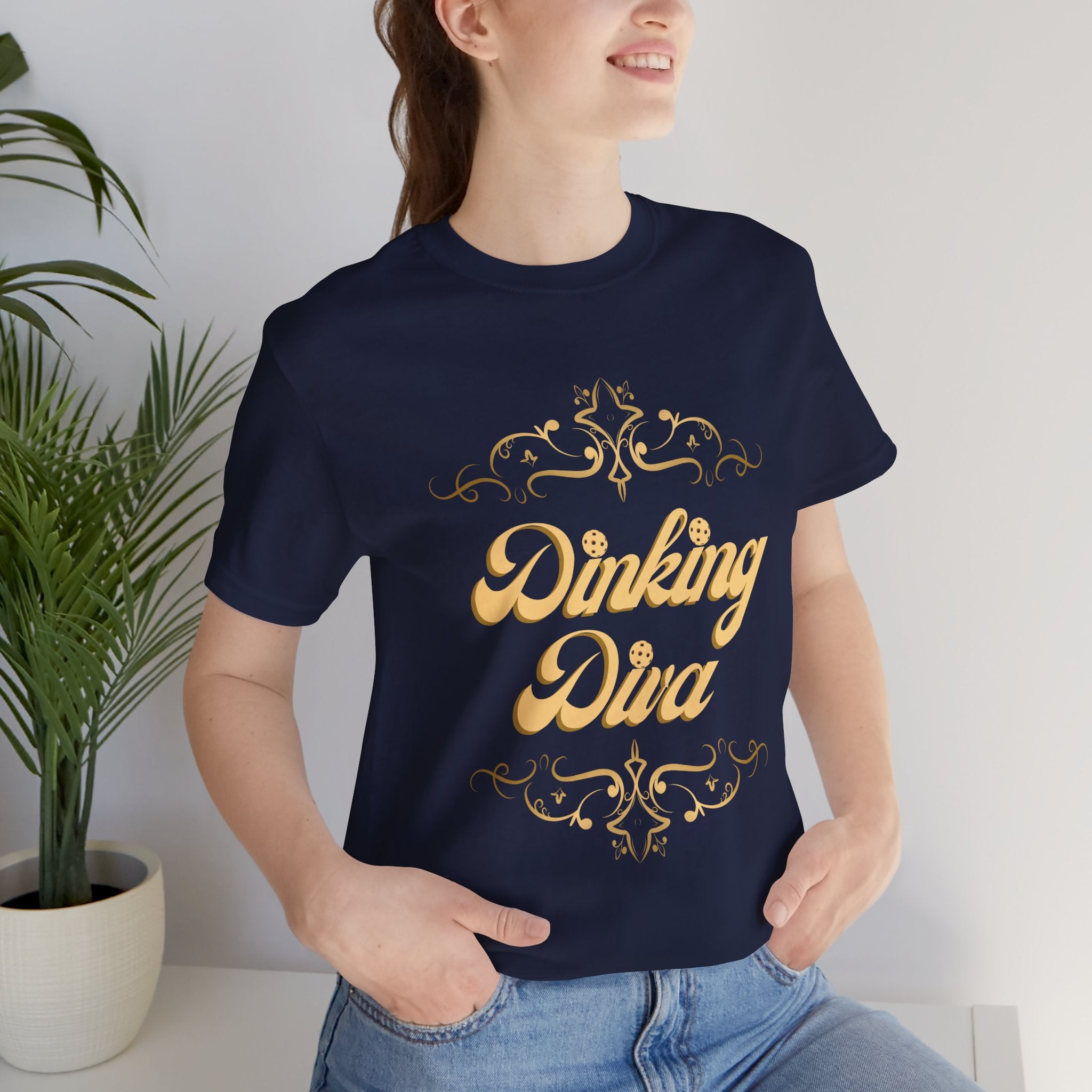 Dinking Diva Pickleball T-shirt in gold filigree design, casual athletic wear by Printify featuring a stylish pickleball graphic.