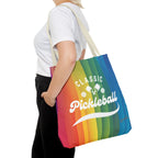 Rainbow tote bag with crossed pickleball paddles and script design, featuring vibrant colors and spacious storage.