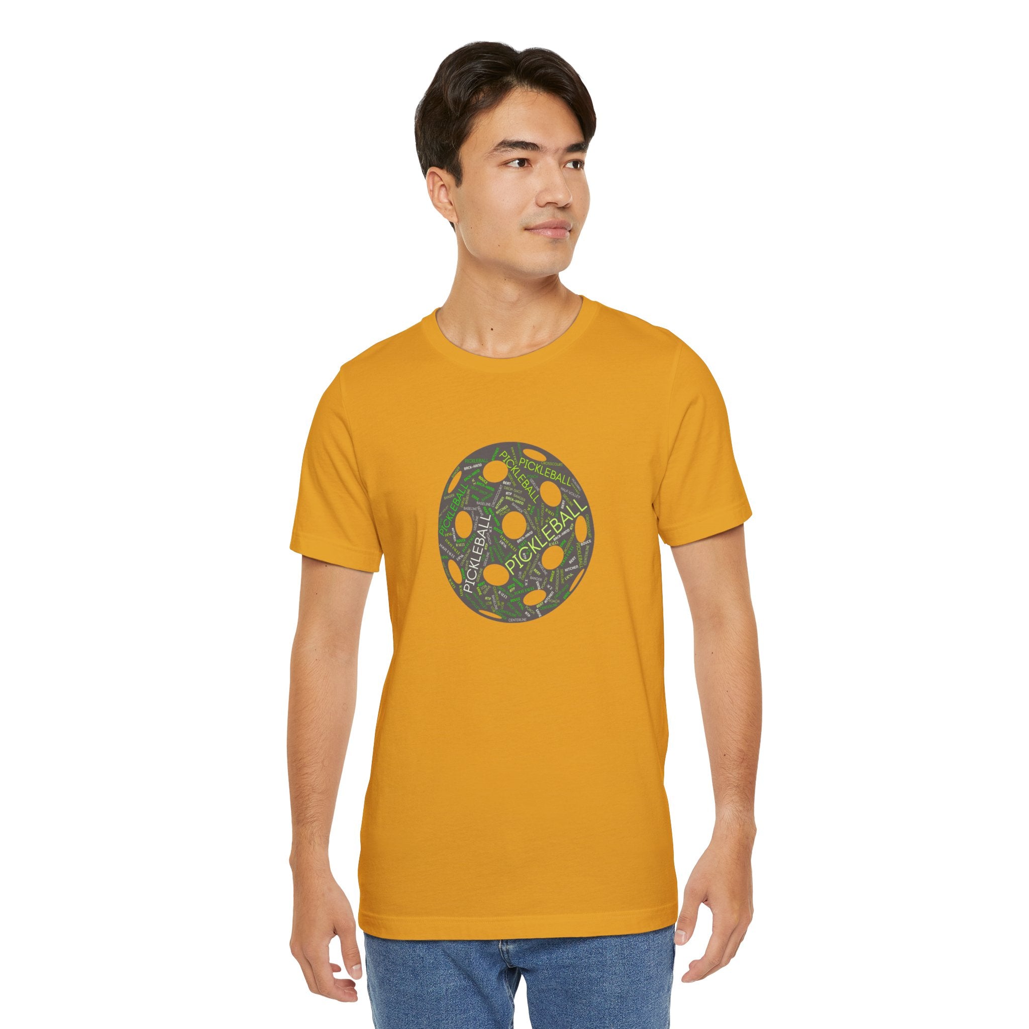 White pickleball-themed T-shirt with a word cloud graphic featuring "Dink," "Pickle," and "Kitchen" in colorful text.