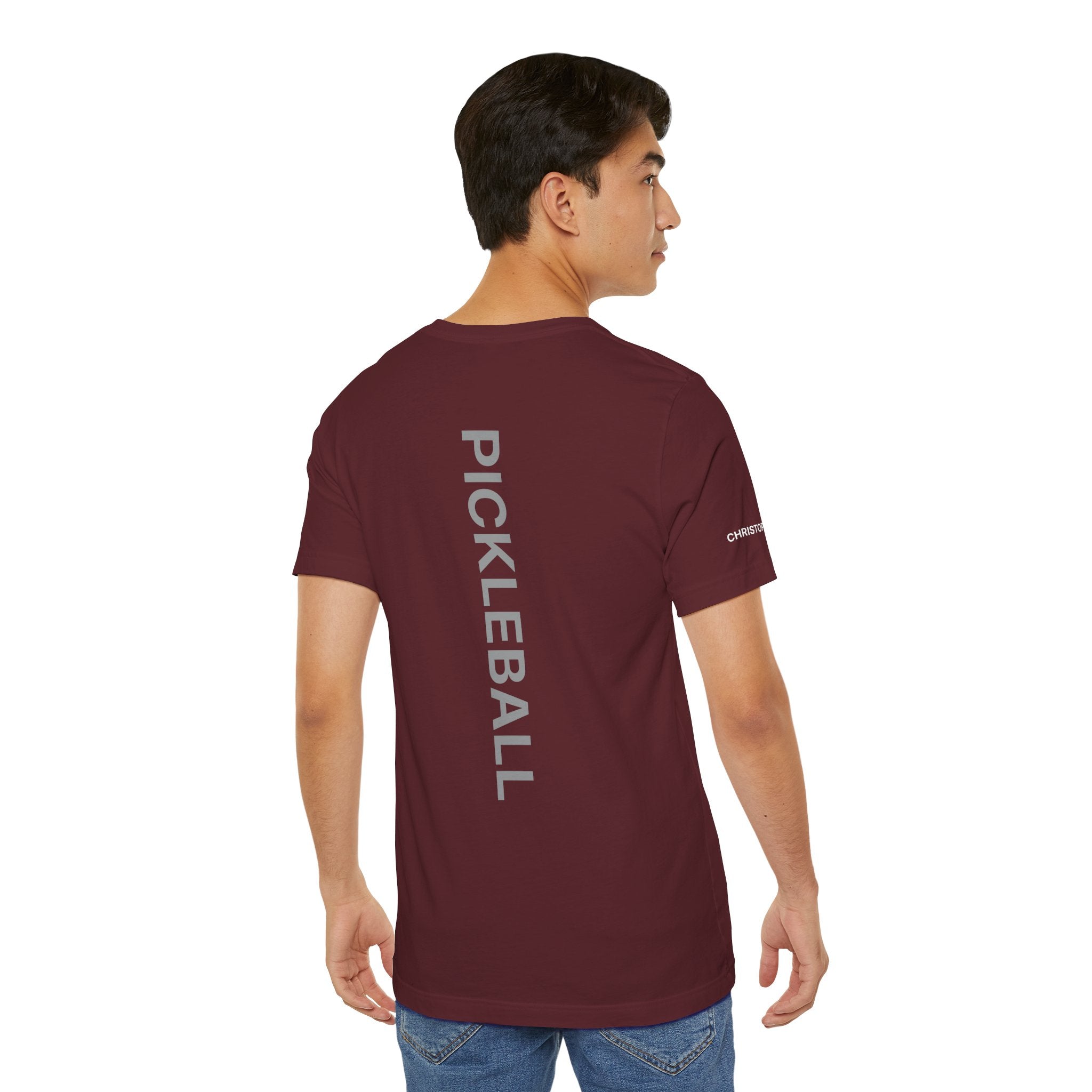 Personalized pickleball T-shirt with custom name sleeve, club logo, and pickleball graphic on the center back by Printify.