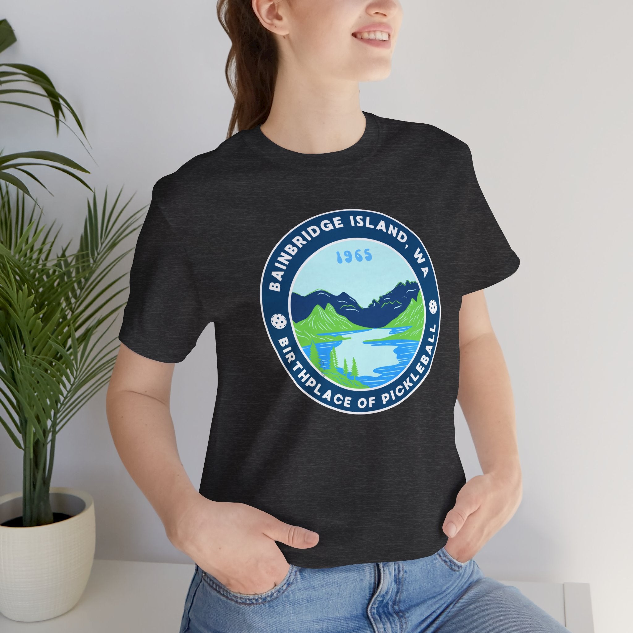 Unisex Bainbridge Island Pickleball T-Shirt featuring "Birthplace of Pickleball 1965" logo in black on white fabric.