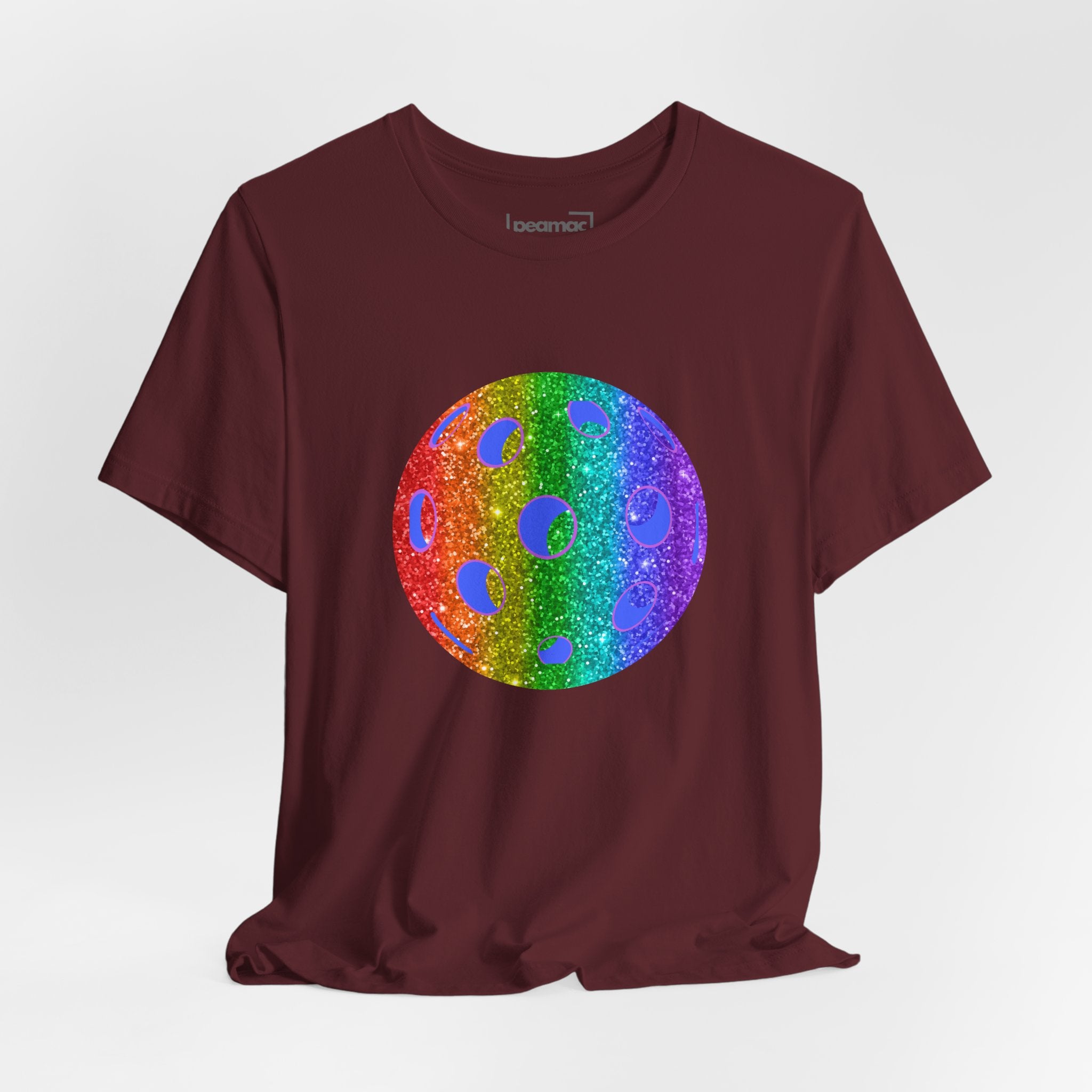 Rainbow glitter pickleball T-shirt with "Proud" slogan from Sparkle Loud and Proud, featuring bright, colorful pride-themed design.
