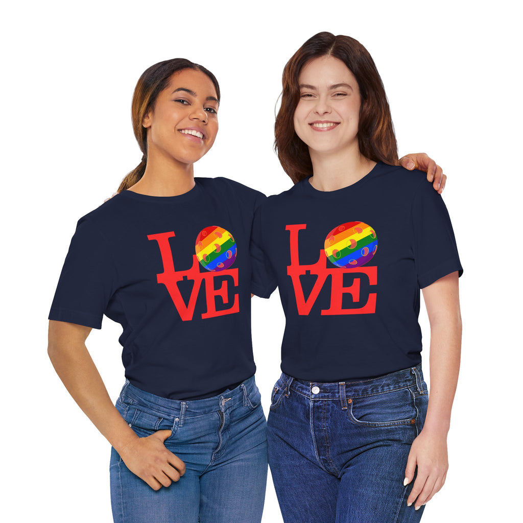 Rainbow LGBTQ2 pride T-shirt featuring "LOVE Pickleball" design, casual fit, worn by a person with colorful background.