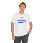 Red and blue pickleball paddle and ball graphic on a classic script tee shirt, ideal for pickleball enthusiasts.
