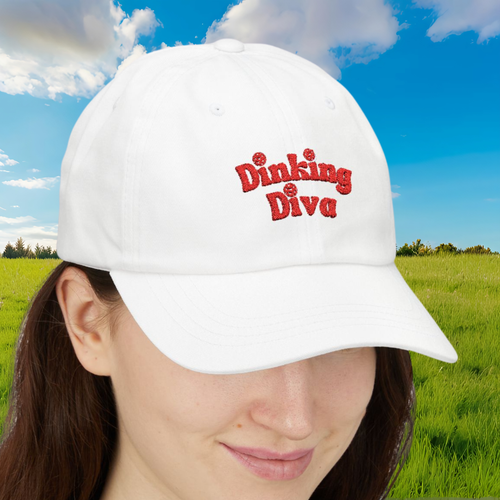Embroidered Dinking Diva pickleball baseball cap with leather and brass closure, shown in a field background.