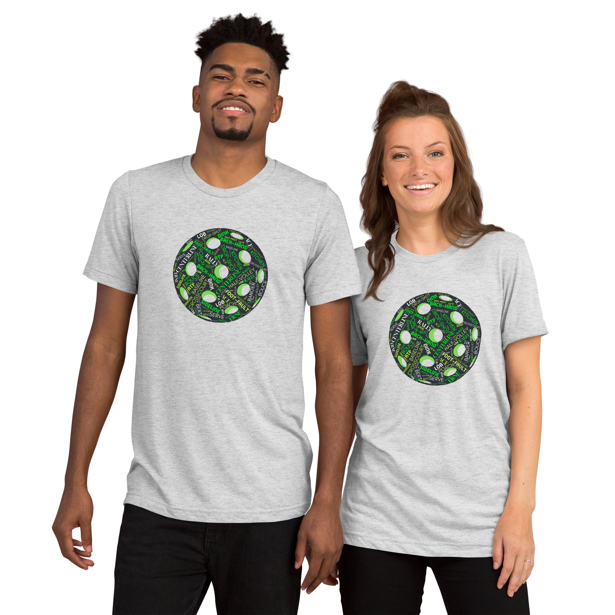 Unisex white tri-blend T-shirt featuring a pickleball word cloud graphic with words like Dink, Pickle, and Kitchen from PeaMac Pickleball Tees.